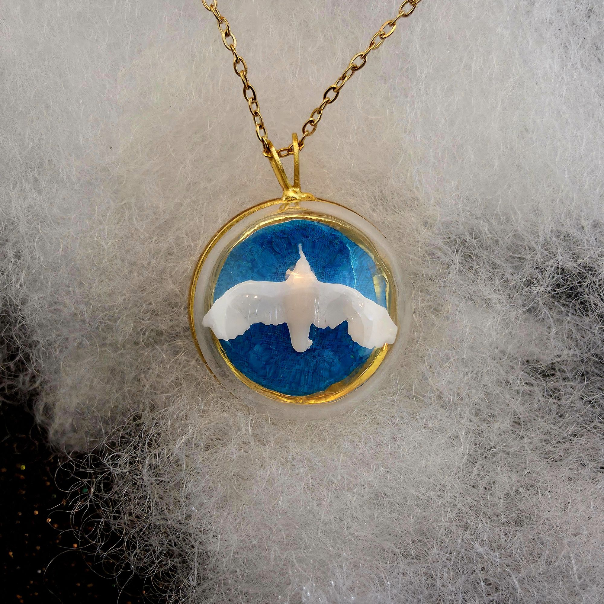 médaillon en métal doré contenant un oiseau albatros blanc sous bulle de verre - petite planete