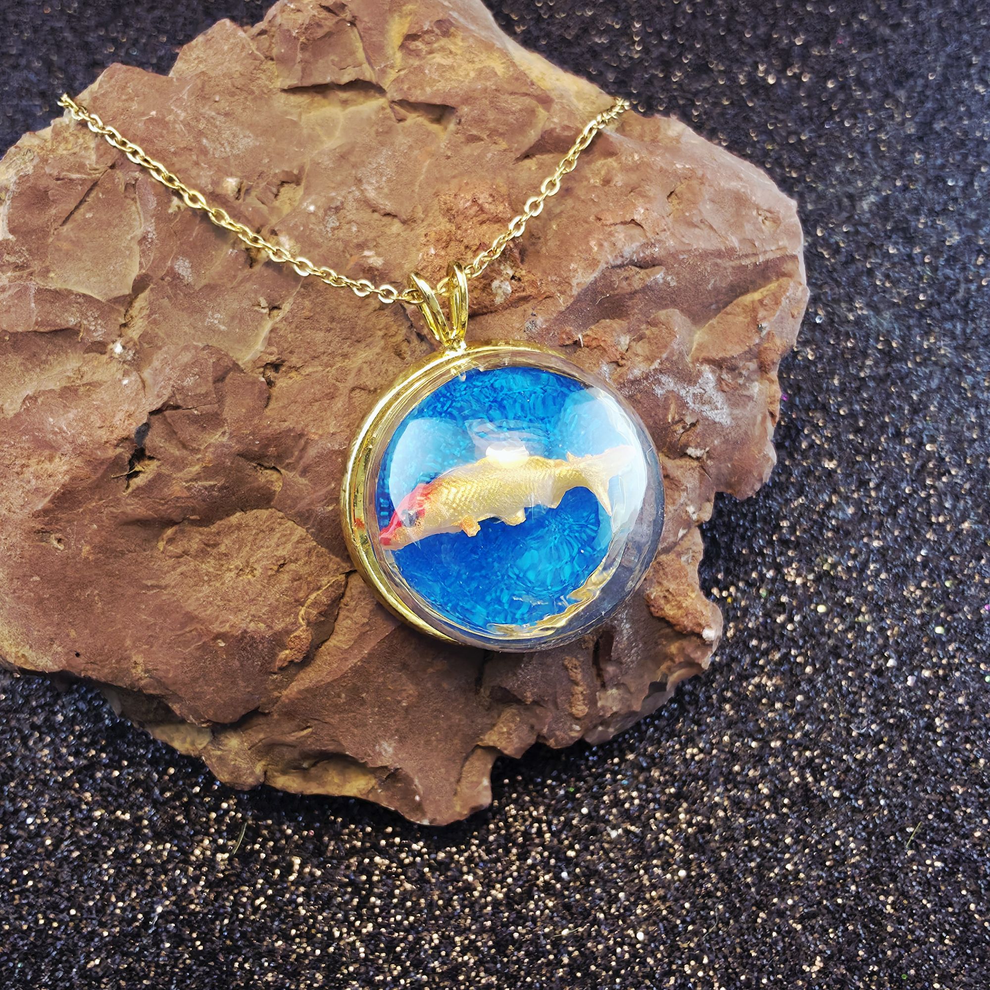 médaillon en métal doré contenant une carpe dorée sous bulle de verre - petite planete