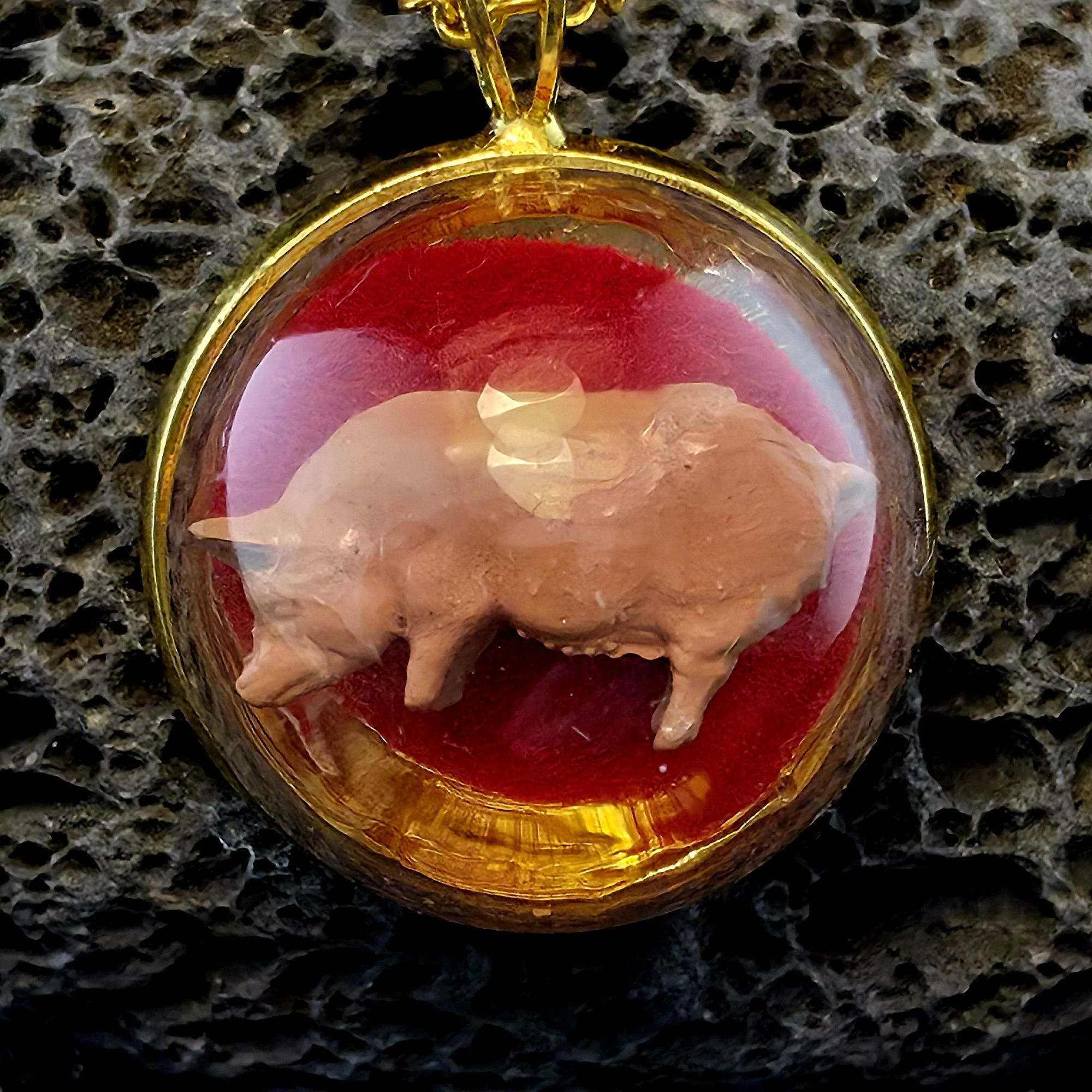 médaillon en métal doré contenant un grand cochon fond fuschia sous bulle de verre - petite planete