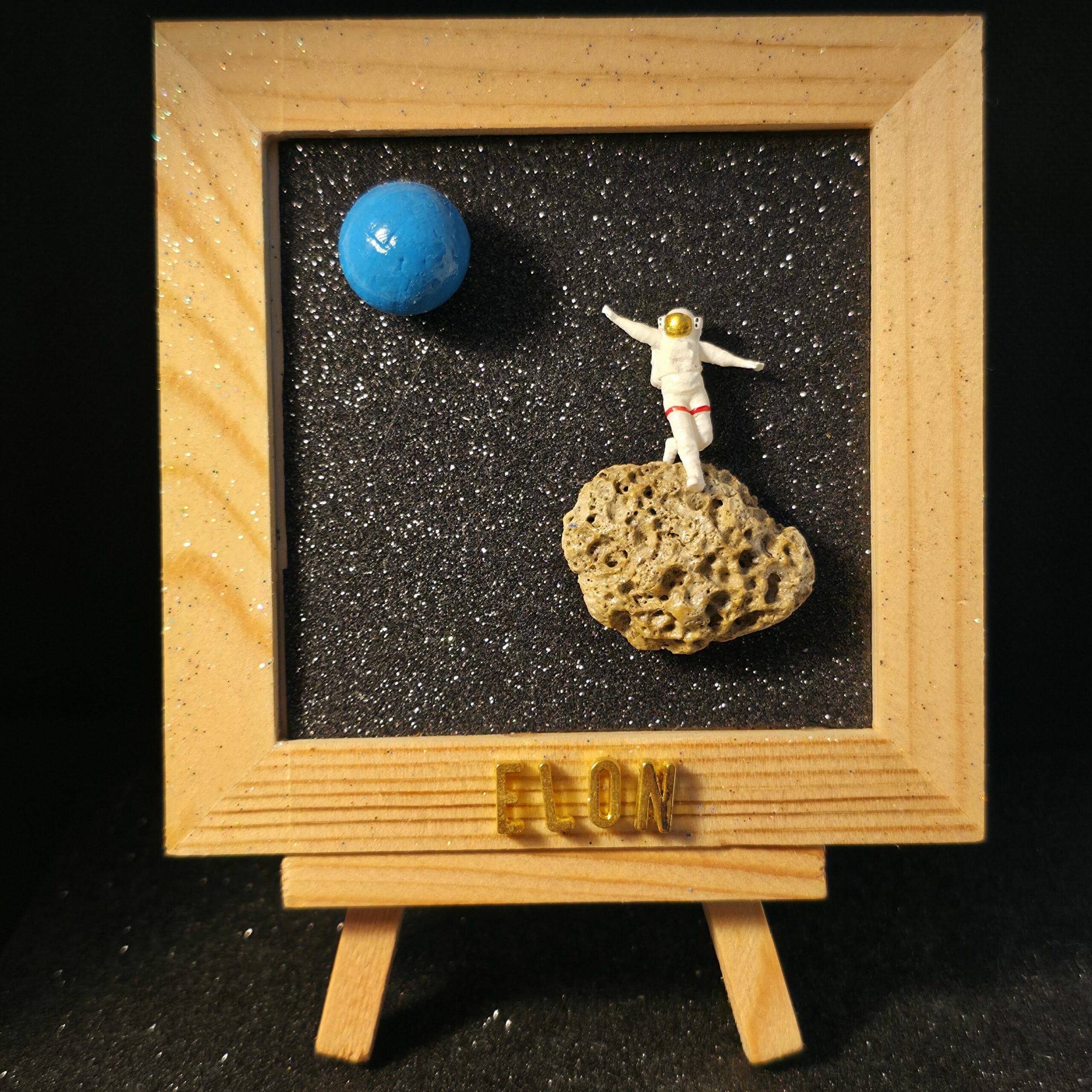 tableau en bois présentant une scène avec un astronaute sur son astéroïde quittant la terre devenue bleue suite à la hausse du niveau des océans - petite planete