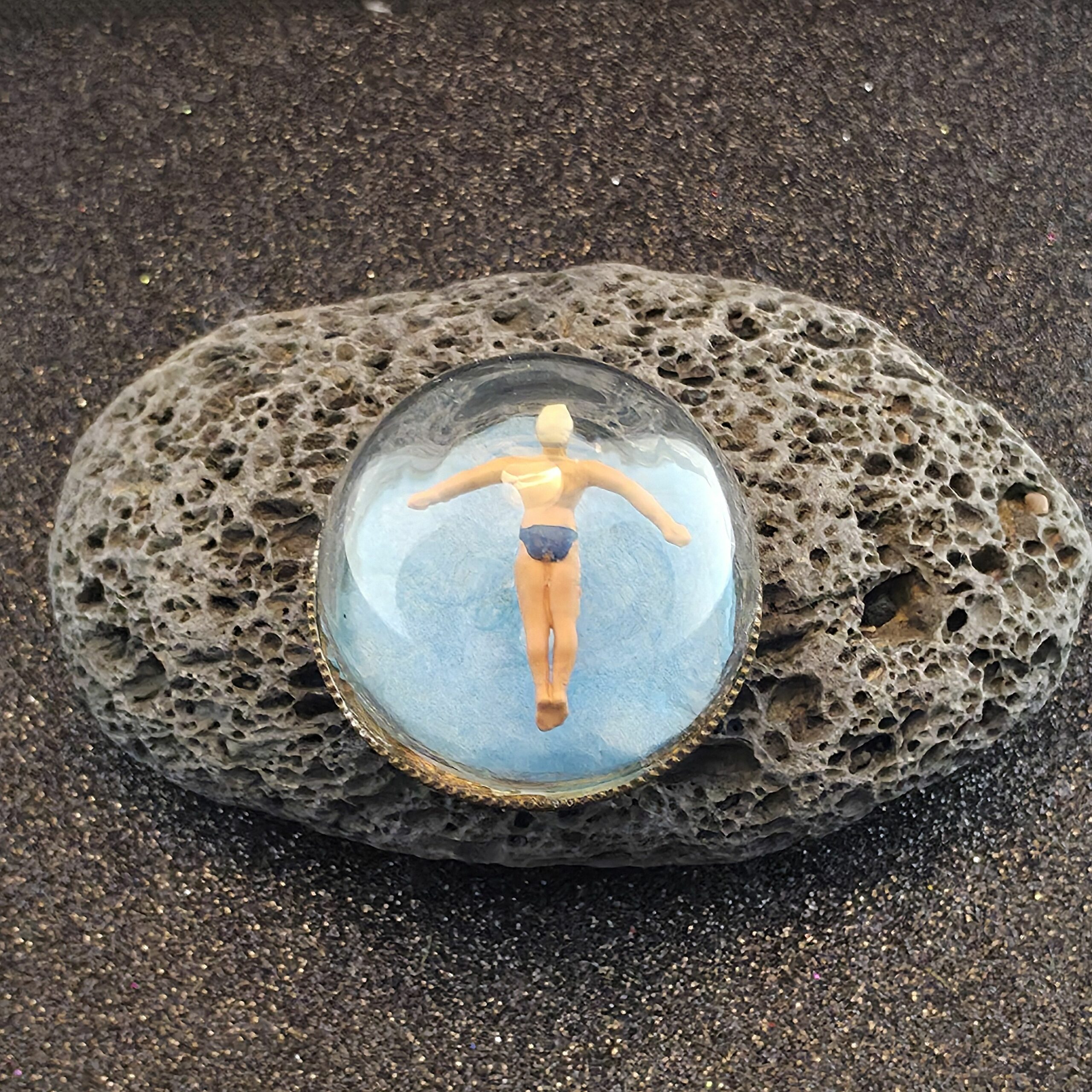 médaillon en métal bronze contenant un plongeur en saut de l'ange sur fond bleue sous une bulle de verre - petite planete