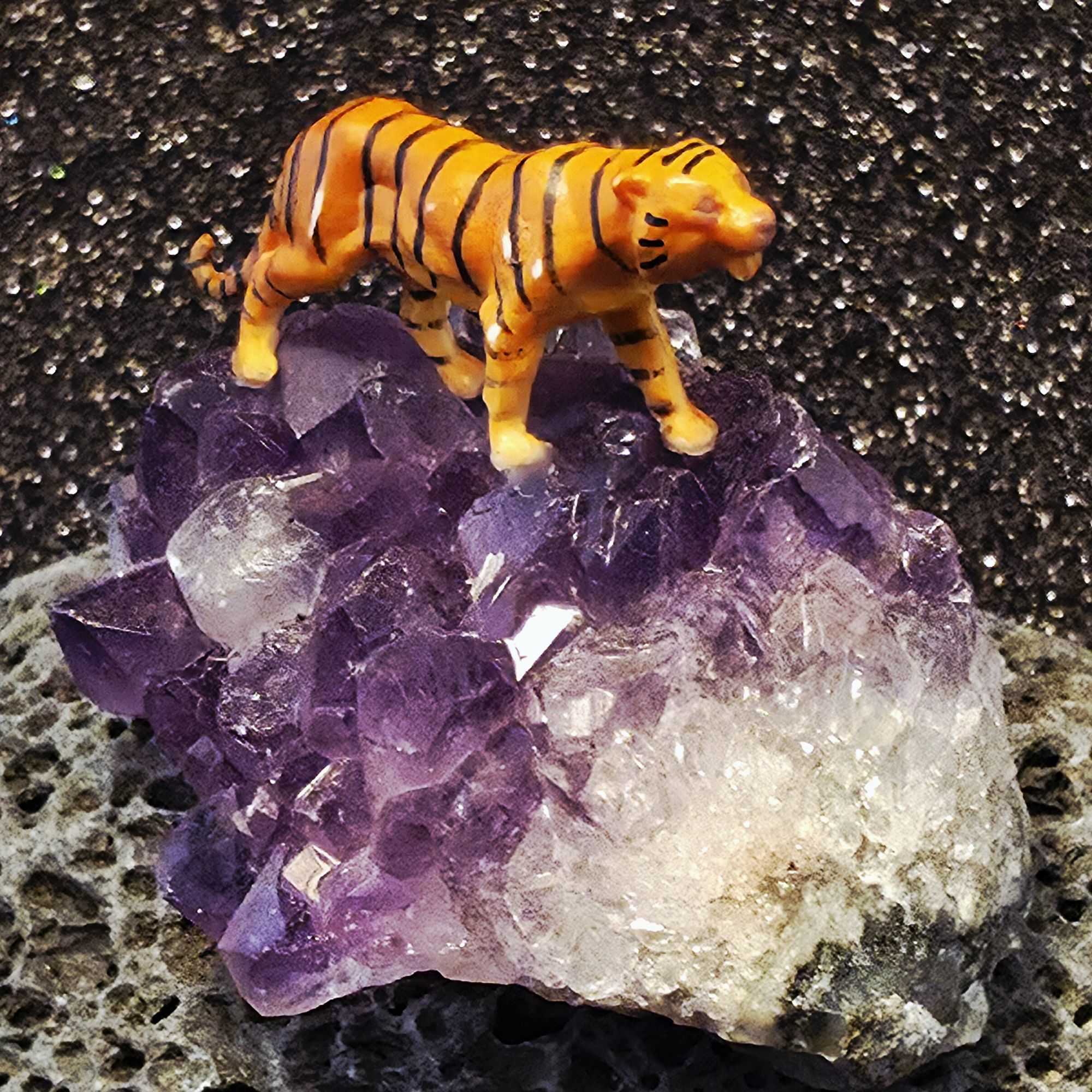 Oeuvre présentant un mini tigre posé sur un cristal d'améthyste